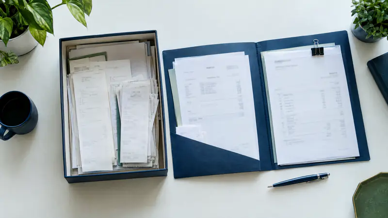 Receipts and invoices organized in a box and folder for business tax preparation