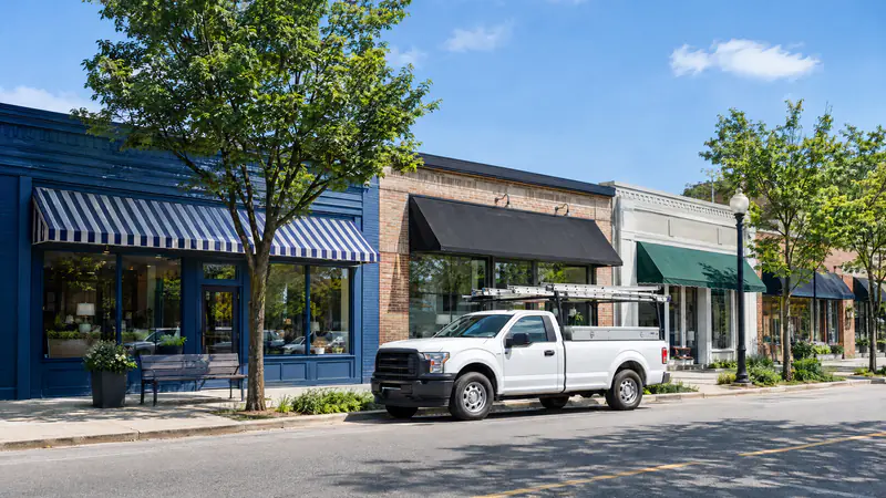 Row of independent neighborhood shops with a contractor's pickup truck parked outside